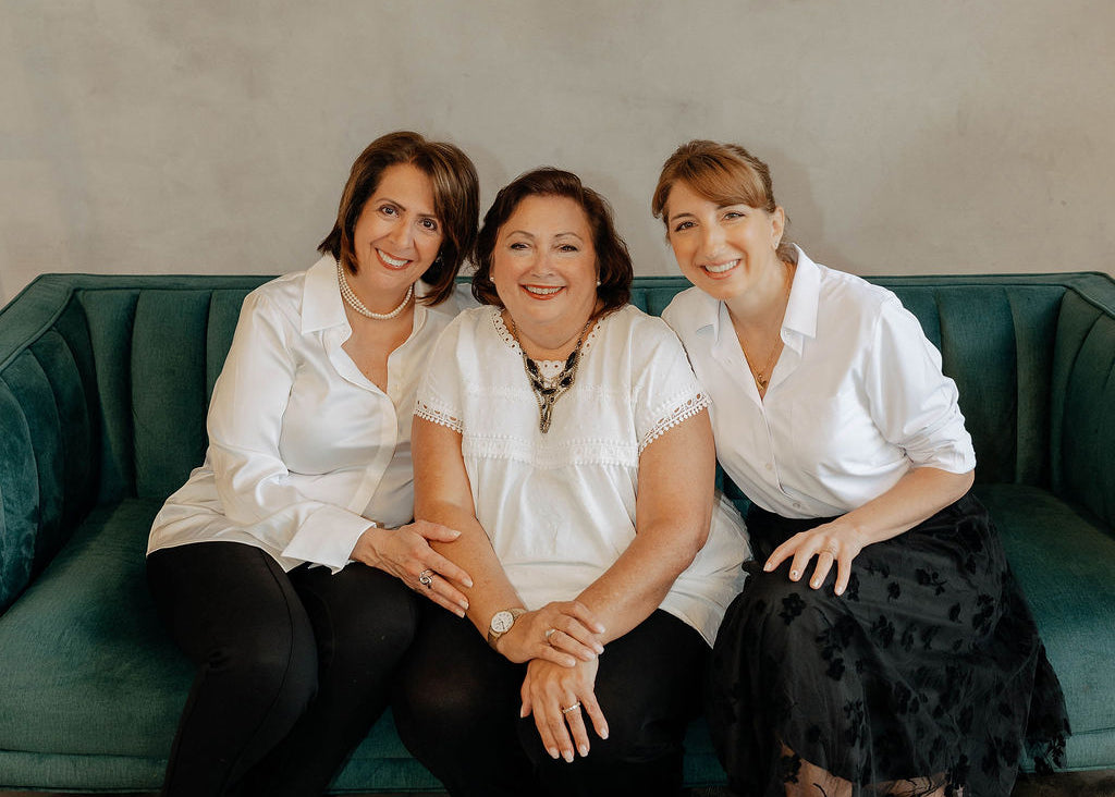 Mary Kelly, Renee Papadoulis, and Nichole Maniscalco standing together on  a teal velvet sofa at The Workplace Community Podcast